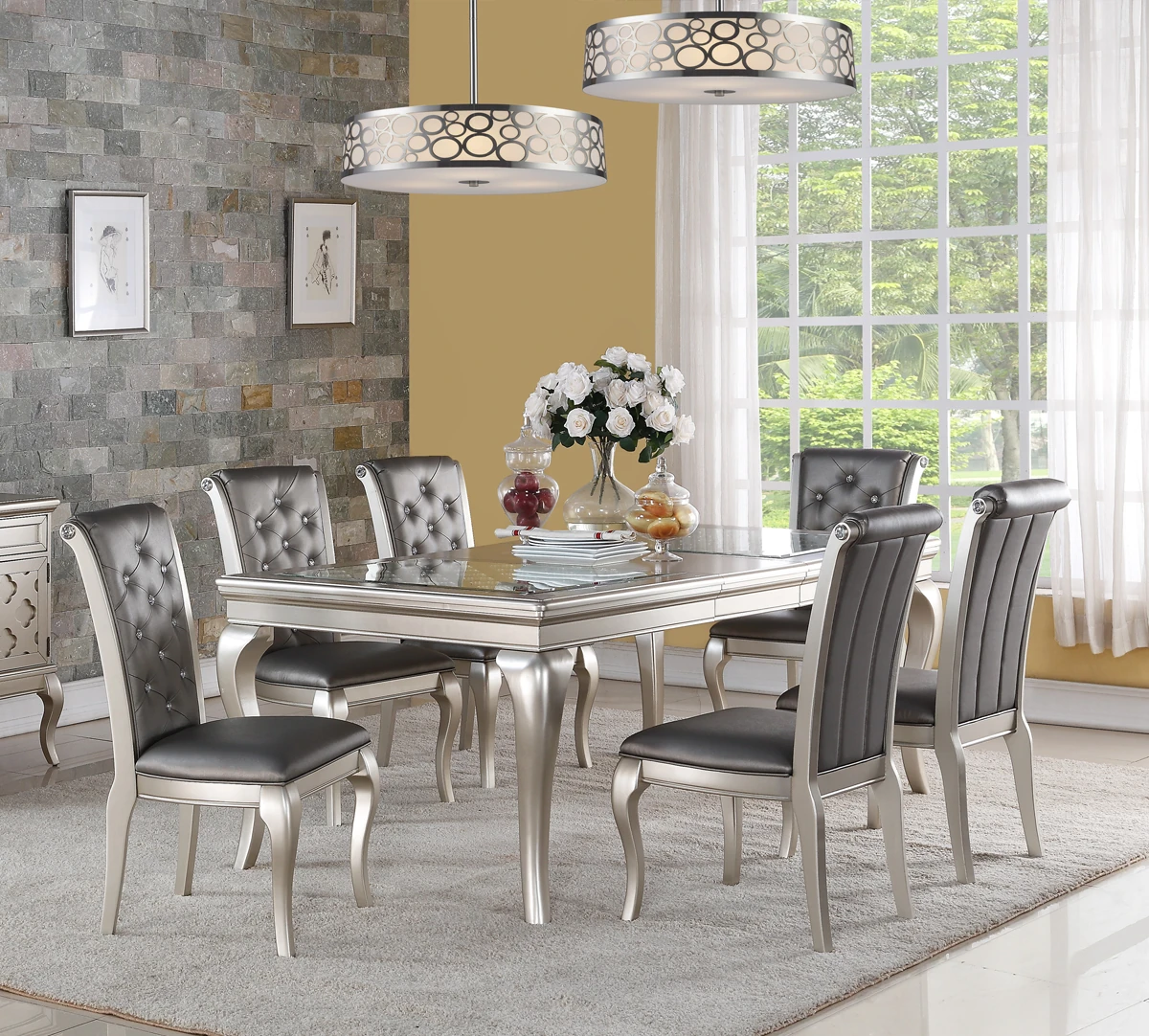 Silver dining table and upholstered chairs in a sunlit dining room.
